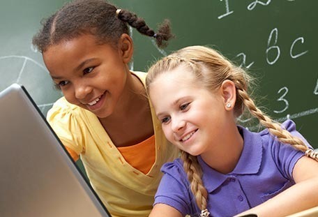 Two children looking at a screen